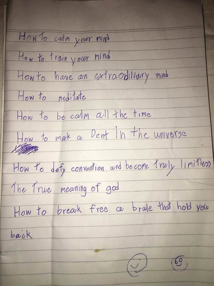 A lined page in Brian's handwriting, nine lines and two smiling faces: "How to calm your mind · How to train your mind · How to have an extraodinary mind · How to meditate · How to be calm all the time · How to mak a Dent in the universe · How to defy convention and become truly limitless · The true meaning of god · How to break free a rule that hold you back." Written one day while he was being homeschooled.
